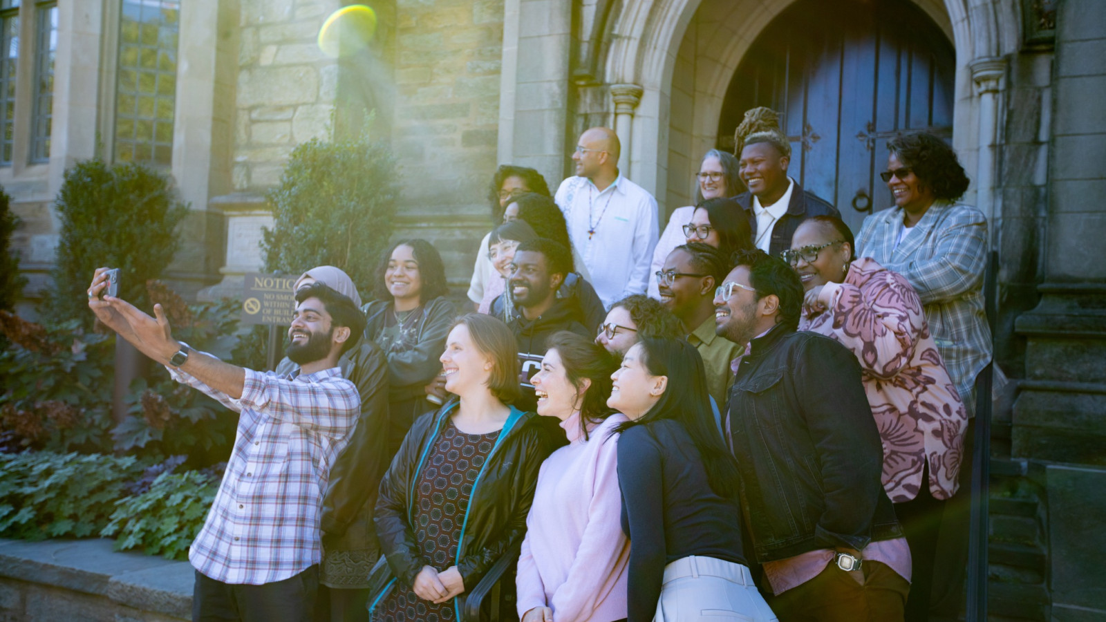 Group taking a selfie on the steps in front of a building